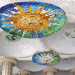 Detalle de un mosaico colorido en forma de sol en el Parque Güell