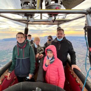 Family enjoying a hot air balloon ride over Empordà.