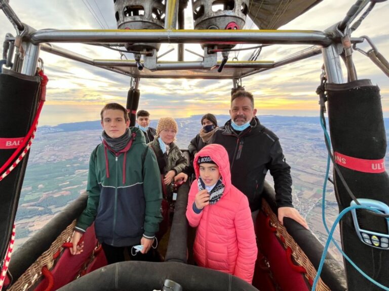 Family enjoying a hot air balloon ride over Empordà.