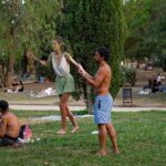 Two people are in one of the green spaces of Ciutadella Park, engaging in some form of scenic or spiritual exercise. Learn how to describe the purpose of the image (opens in a new tab). Leave it empty if the image is purely decorative.