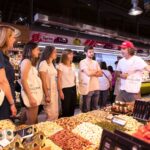 Chef explaining spices to participants at La Boqueria market.