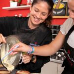 Image of a student and chef preparing Crema Catalana together in the kitchen.