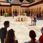 A group observes the Alhambra as the tour progresses in one of the monument's courtyards.