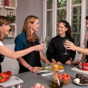Guests raising their glasses in a toast during the cooking class, enjoying unlimited servings of premium Spanish wines.