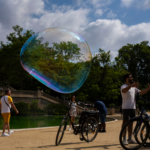 Artistic photo of a soap bubble with guide explaining bicycles around Parc de la Ciutadella fountain, Barcelona.