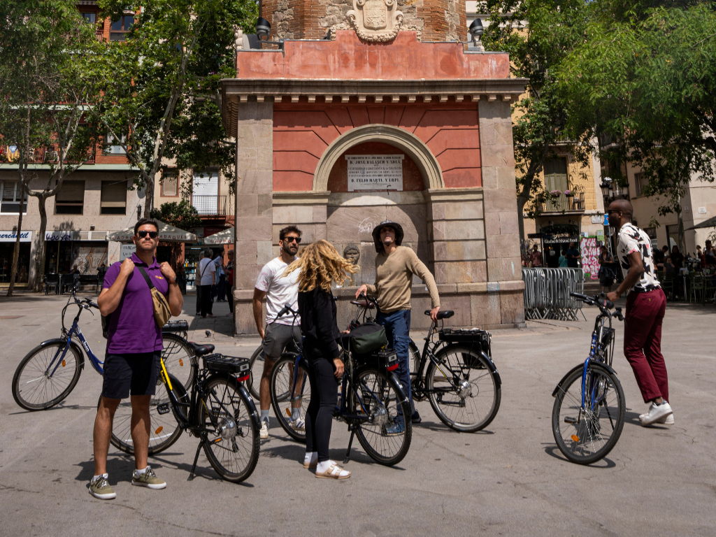 Group of people with bikes looking at the camera in Gràcia, Barcelona.