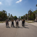 Group of cyclists on electric bikes along Passeig de Lluís Companys in Barcelona.