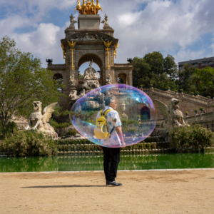 Artistic photo of a man inside a soap bubble at the fountain in Parc de la Ciutadella, Barcelona.
