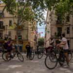 Group receiving instructions while seated on bikes in Gràcia, Barcelona.