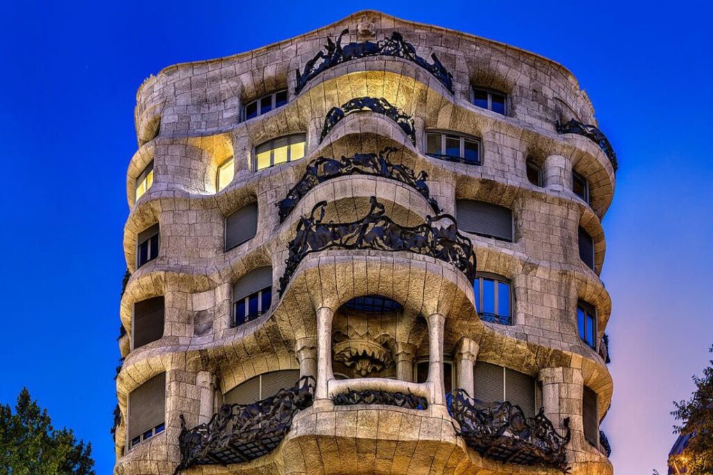 Casa Milà illuminated at night in Barcelona.